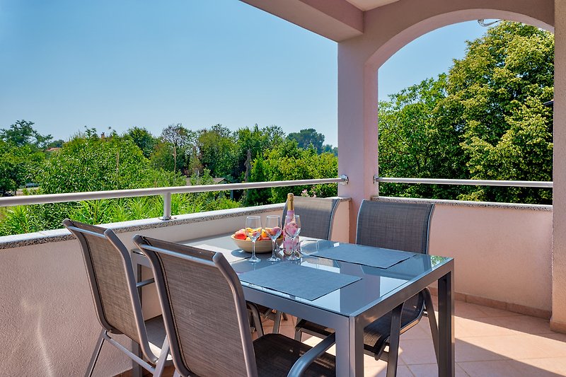 Elegante Terrasse mit Holztisch, Stühlen und Blumen.