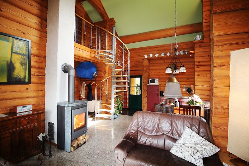 Gemütliches Wohnzimmer mit Holzmöbeln, großem Fenster und bequemer Couch.