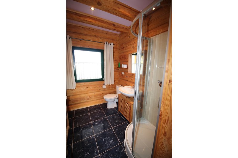 Gemütliches Badezimmer mit Holzboden und modernen Armaturen.