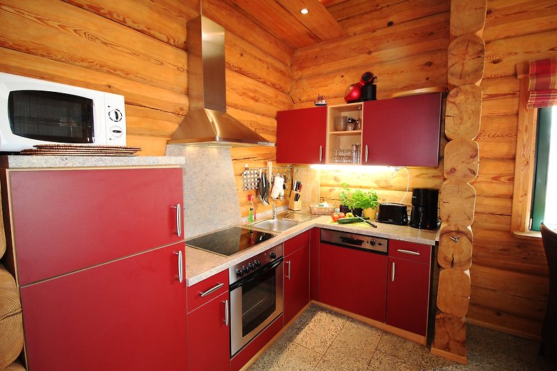 Gemütliche Küche mit Holzmöbeln, Spüle und Küchengeräten.