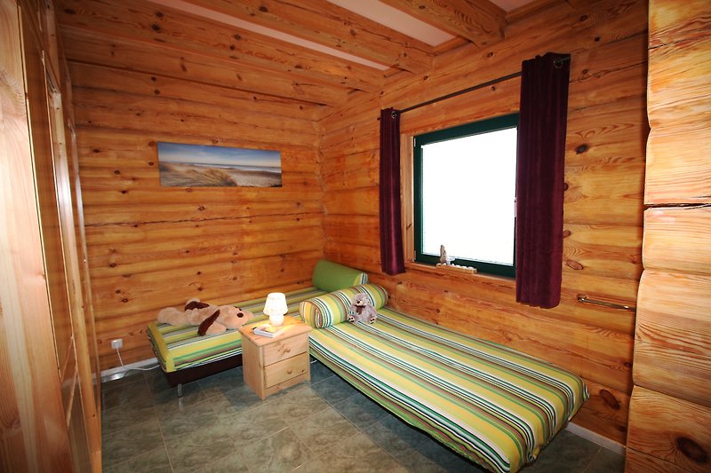 Gemütliches Wohnzimmer mit Holzboden, bequemen Möbeln und großen Fenstern.