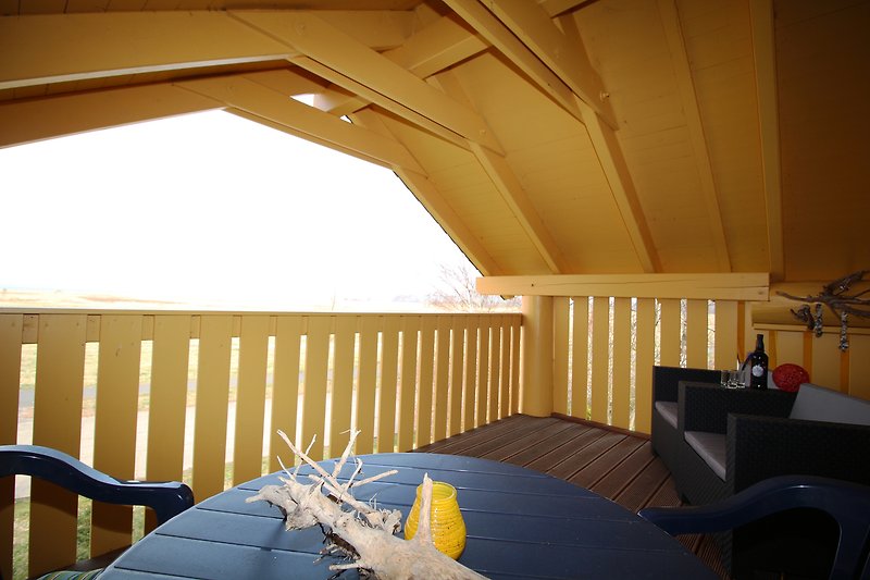 Holzhaus mit gemütlicher Einrichtung, Balkon und Meerblick. Perfekt für einen erholsamen Urlaub am Wasser.