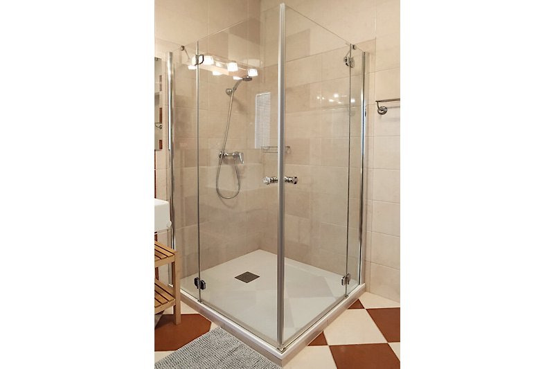 Ein modernes Badezimmer mit transparenter Duschtür und stilvoller Ausstattung.
