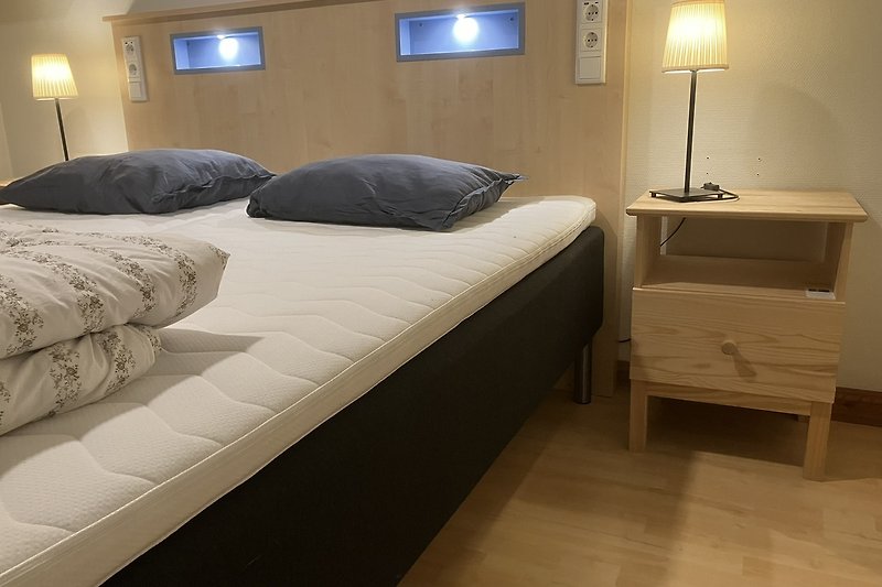 Schlafzimmer mit elegantem Design, gemütlichem Boxspring Betten  und stilvoller Beleuchtung.