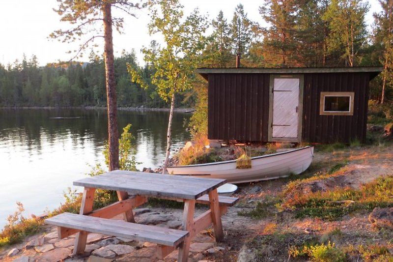 Sauna, Boot und Sitzbereich beim Ufer.