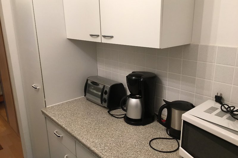 Küchenzeile mit kleinem Backofen, Mikrowelle, Toaster, Wasserkocher und Kaffeemaschine, 2 Platten Herd Kühlschrank
