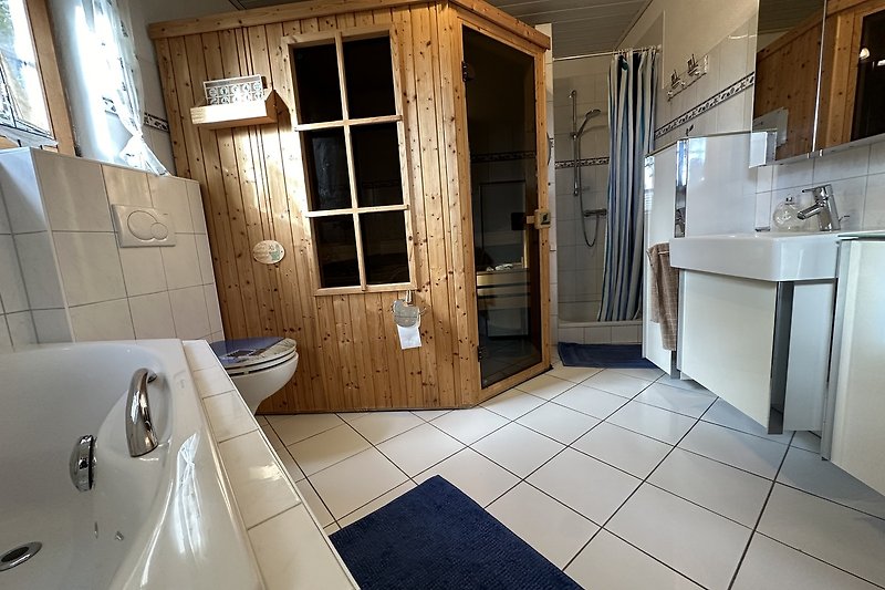 Badezimmer mit Sauna und Whirl-Badewanne
