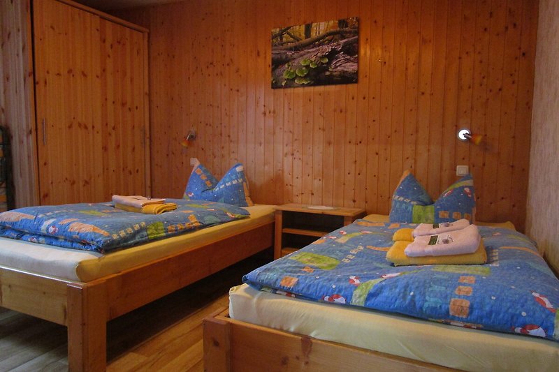 Elegantes Schlafzimmer mit Holzmöbeln und gemütlicher Bettwäsche.