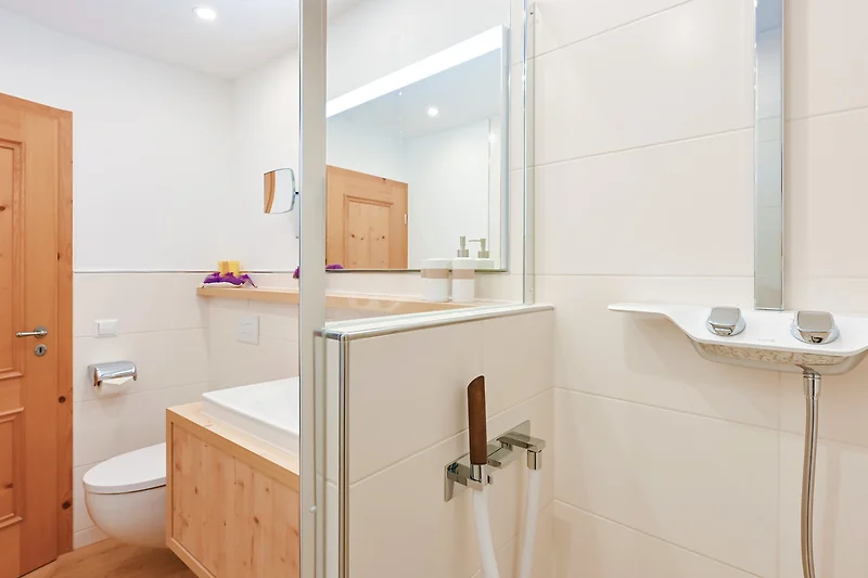 Geräumiges Bad mit Badewanne, Doppelwaschbecken und großem Spiegel.