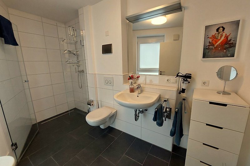 Badezimmer mit lila Akzenten, Spiegel und Waschbecken.