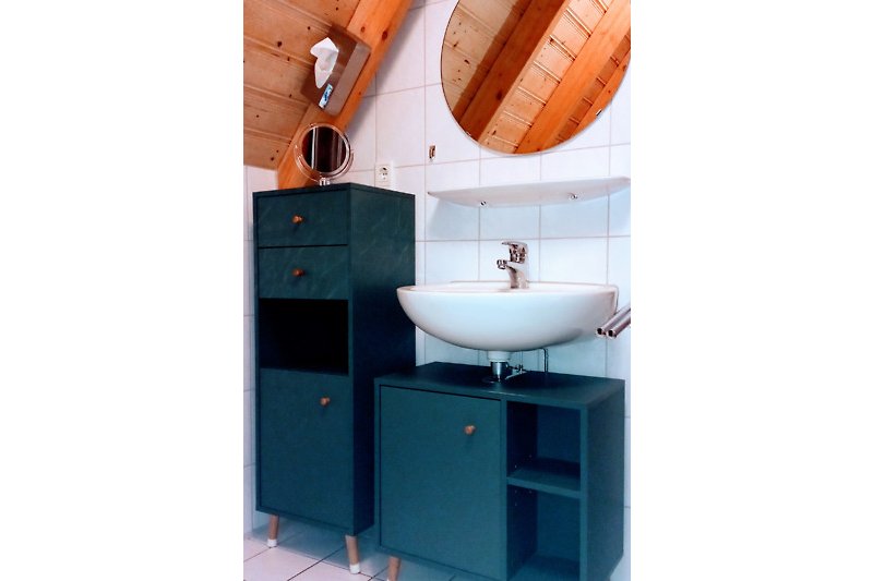 Ein modernes Badezimmer mit Holzwaschbecken und Spiegel.