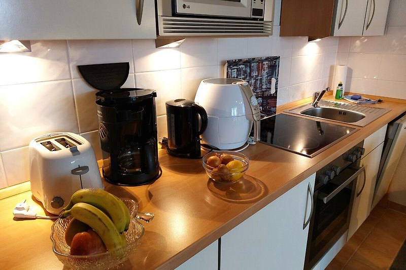 Küche mit modernen Geräten und Kochutensilien.