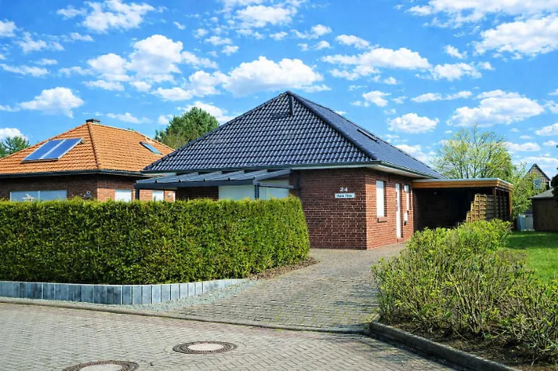 Großzügiger Garten, gepflegte Einfahrt und markante Dacharchitektur.