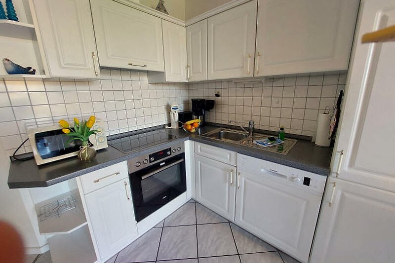Moderne Küche mit eleganten Schränken und Granitarbeitsplatte.