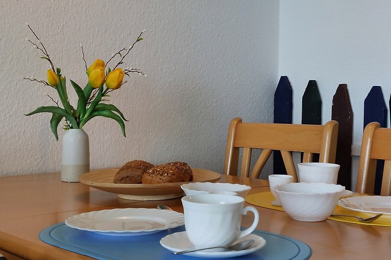 Moderne Tischdekoration mit Pflanzen und Geschirr. Gemütliche Atmosphäre.