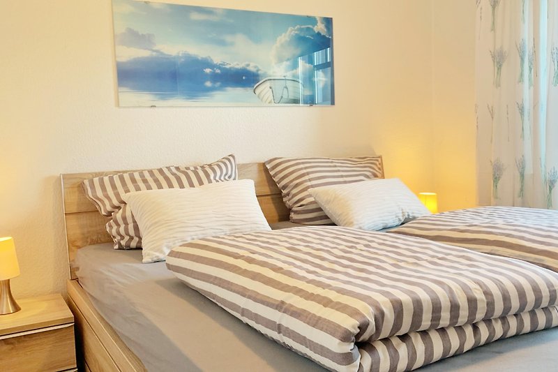 Gemütliches Schlafzimmer mit bequemem Bett, Holzmöbeln und gemütlicher Beleuchtung.