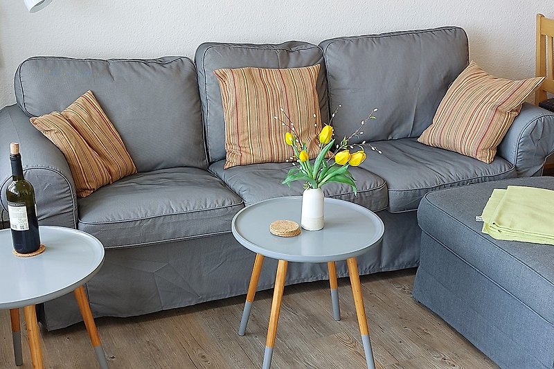 Modernes Wohnzimmer mit bequemer Couch und gelber Blume.