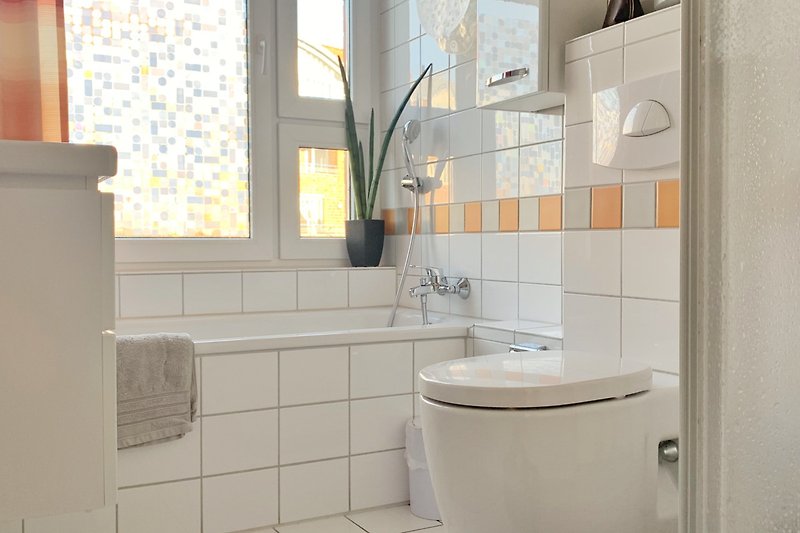 Gemütliches Badezimmer mit lila Vorhang, Spiegel und Toilette.