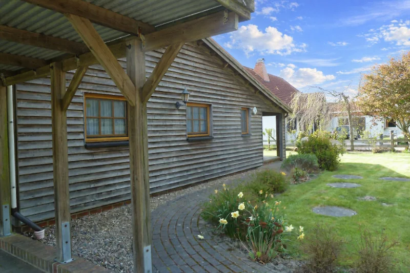 Großes Bauernhaus mit Veranda, Garten, Einfahrt und Holzdeck.