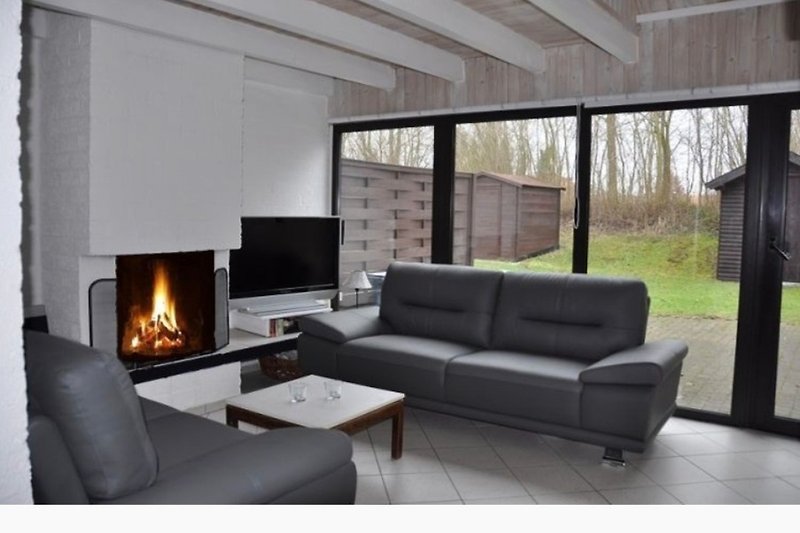 Einladendes Wohnzimmer mit Kamin, Sofa und stilvoller Beleuchtung.