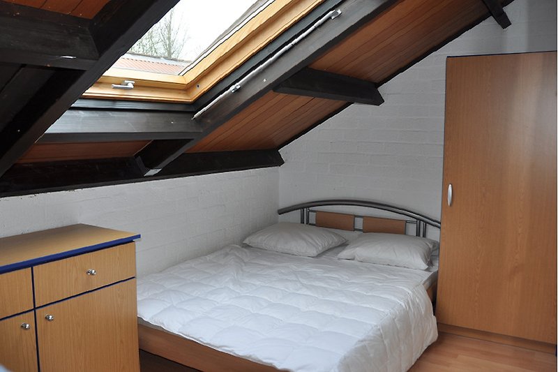 Komfortables Schlafzimmer mit Holzboden und gemütlichem Bett.