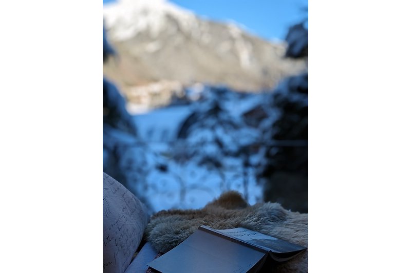 Beeindruckende Berglandschaft mit blauem Himmel und schneebedeckten Gipfeln. Sitzfenster, gemütlicher Platz zum Lesen