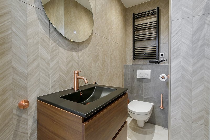 Elegantes Badezimmer mit Spiegel, Waschbecken und Holzdetails. Tapete und Marmor verleihen Stil.