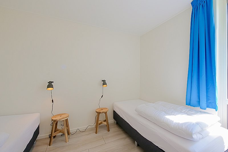 Schlafzimmer mit bequemem Bett, Holzmöbeln und Kunst.