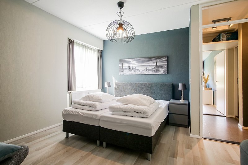 Gemütliches Schlafzimmer mit stilvollem Holzboden und moderner Einrichtung.