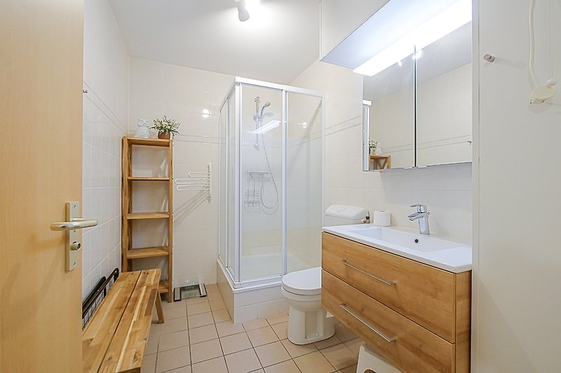 Badezimmer mit Spiegel, Waschbecken und Armatur.