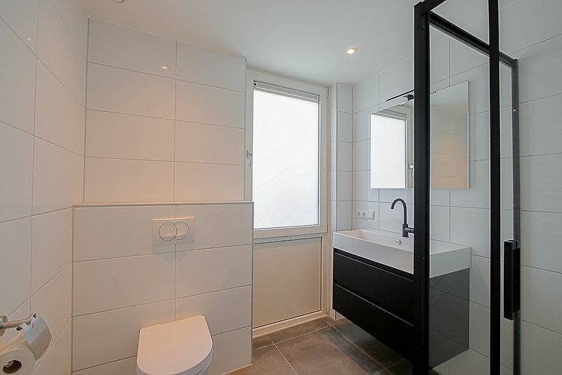 Modernes Badezimmer mit Glasdusche, Holzdecke und Keramikfliesen.