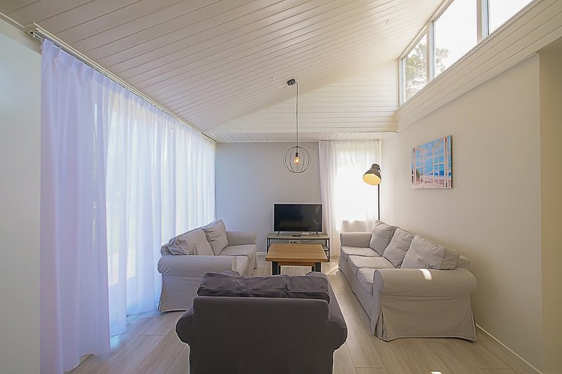 Stilvolles Wohnzimmer mit Holzmöbeln und grauem Sofa.