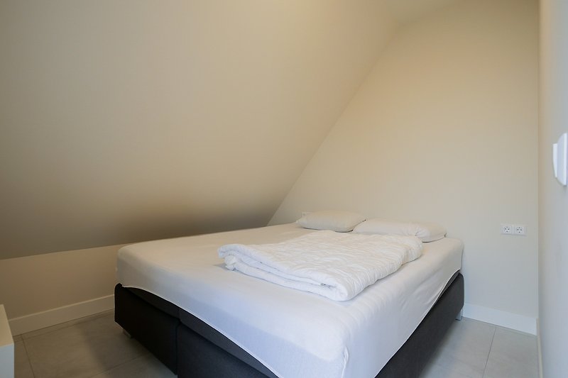 Schlafzimmer mit gemütlichem Bett und stilvollem Interieur.
