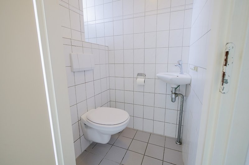 Badezimmer mit lila Toilette und Keramikfliesen.
