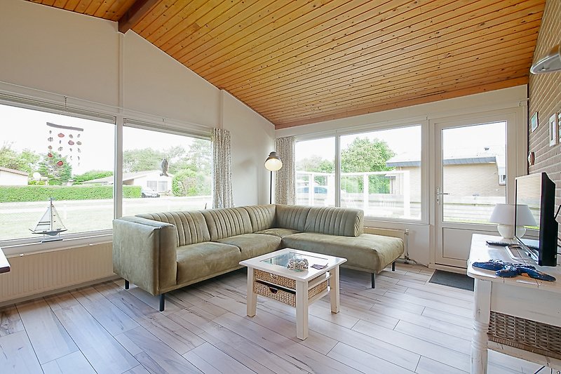 Wohnzimmer mit moderner Einrichtung und Holzbalken.
