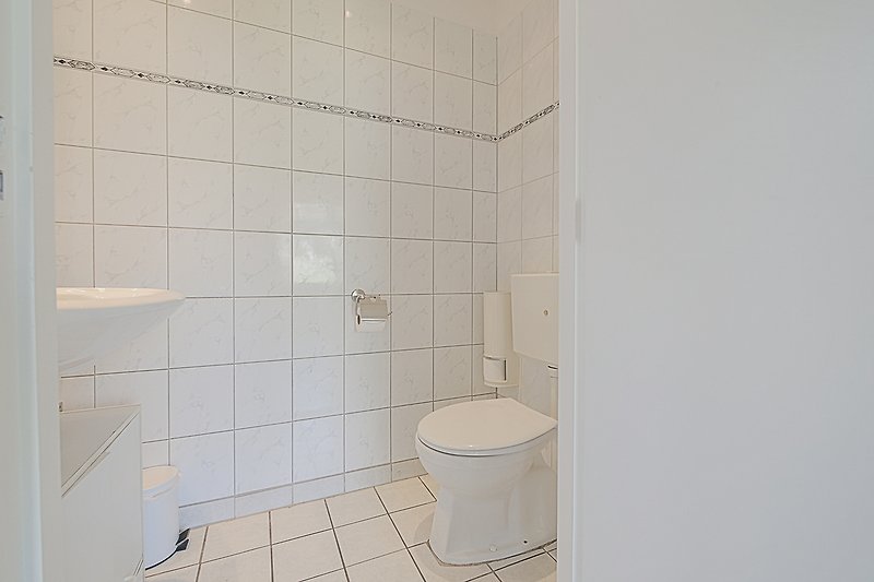 Schönes Badezimmer mit Holzboden, Keramikfliesen und stilvoller Armatur.
