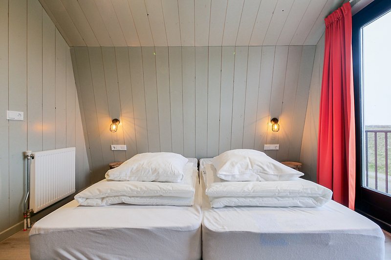 Schlafzimmer mit Holzbett, Vorhang und Lampe. Gemütlich und einladend.
