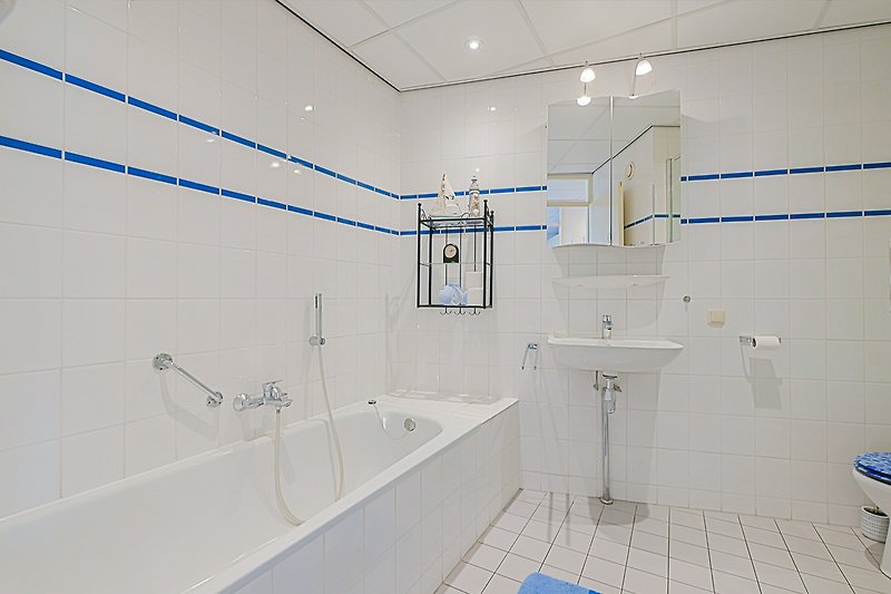 Modernes Badezimmer mit blauer Badewanne und Dusche.