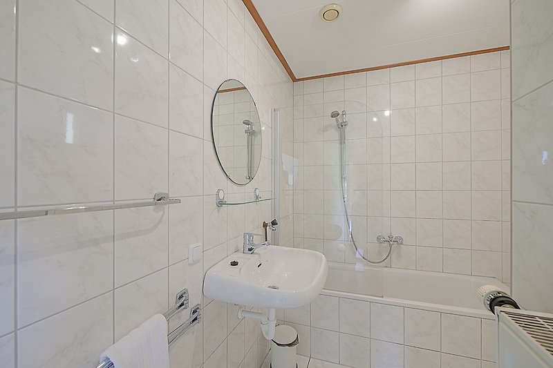 Badezimmer mit lila Waschbecken, Dusche und Fliesen.