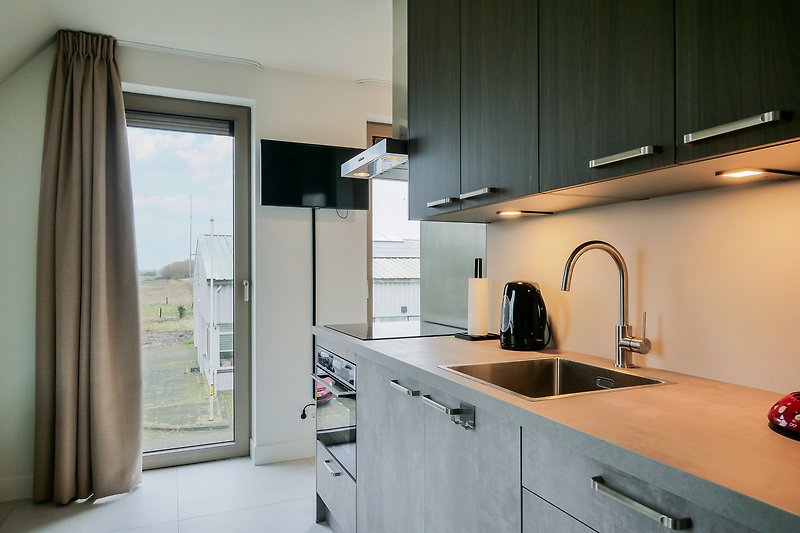 Moderne Küche mit eleganten Schränken und Fensterblick.