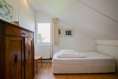 Gemütliches Schlafzimmer mit Holzmöbeln, bequemem Bett und Fensterblick.