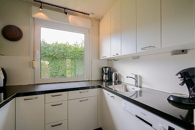 Moderne Küche mit eleganten Schränken und Fensterblick.