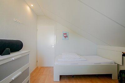 Schlafzimmer mit bequemem Bett, Holzmöbeln und Tageslicht.