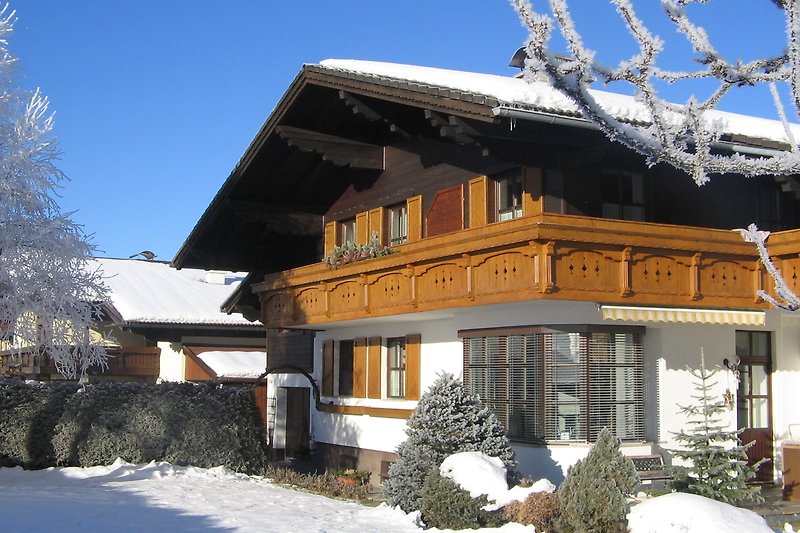 Ein winterliches Bergchalet mit traditioneller Architektur und malerischer Landschaft.