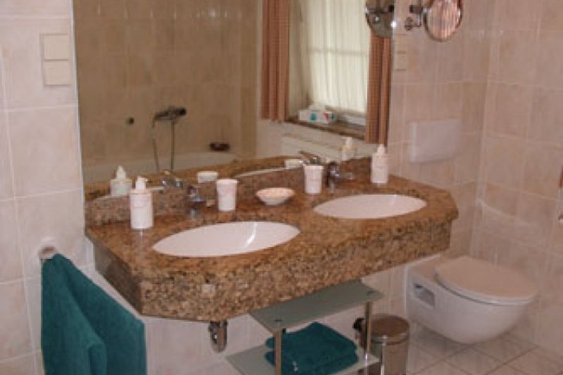 Das Badezimmer mit Wanne, Dusche, WC sowie zwei Waschtischen.
Ein separates Gäste-WC steht ebenfalls zur Verfügung.