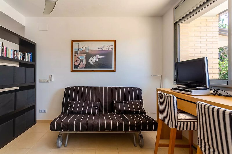 Stilvolles Wohnzimmer mit bequemer Couch und Fernseher.