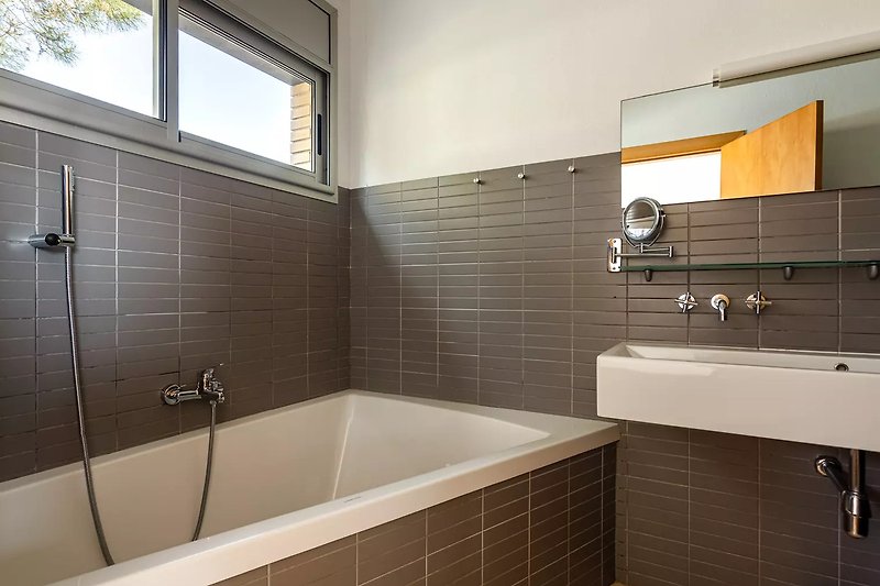 Modernes Badezimmer mit Badewanne und Dusche.