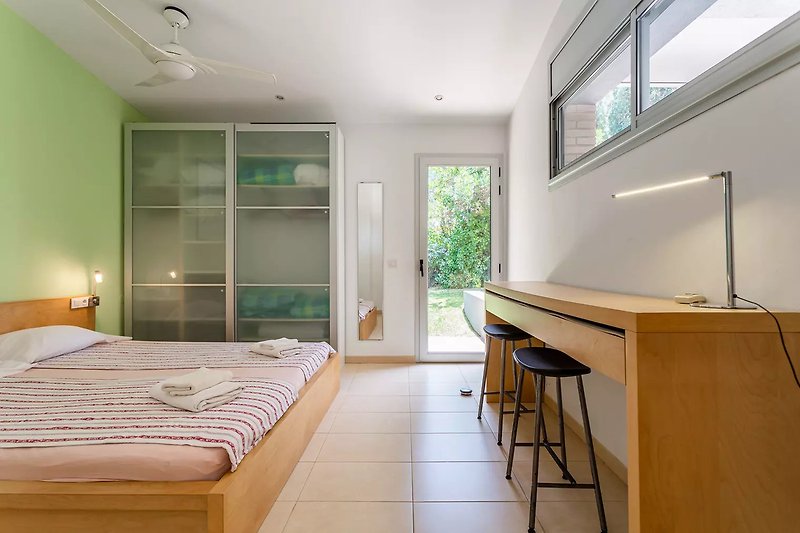 Geräumiges Schlafzimmer mit bequemem Bett 180x200 cm und Schrank. Direkter Zugang zum Garten