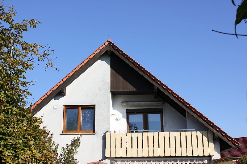 Charmantes Landhaus mit Holzfassade, Veranda und üppigem Garten.