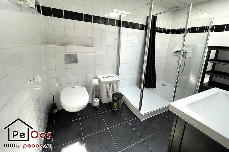 Monochrome Badezimmer mit moderner Dusche und Glasdetails.